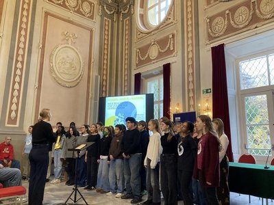 Kinder und Jugendliche beim Singen in einem prunkvollen Raum