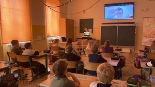 Schulklasse bei einem virtuellen Besuch einer Wissenschaftsbotschafterin