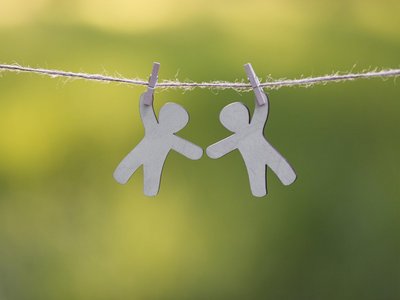 zwei Figuren hängen an einer Leine und geben sich die Hand