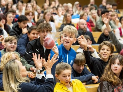 Schülerinnen und Schüler bei der Science Show - sie werfen einen eisgekühlten Luftballon