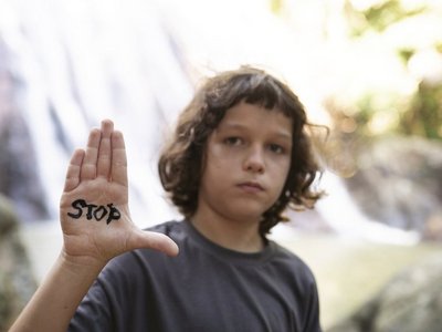 Junge mit der Aufschrift "Stop" auf der Hand