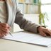 Person mit Stift und Zettel