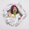 Jugendliche im Labormantel bricht aus einer Papierwand durch