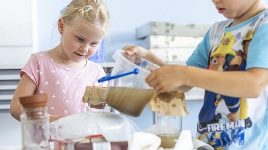 Mädchen und Bub führen ein Experiment durch