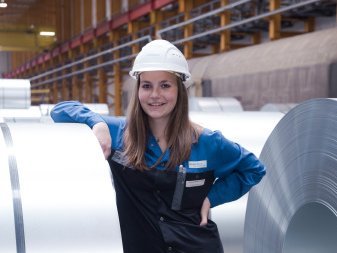 Mädchen neben einer großen Rolle Stahl